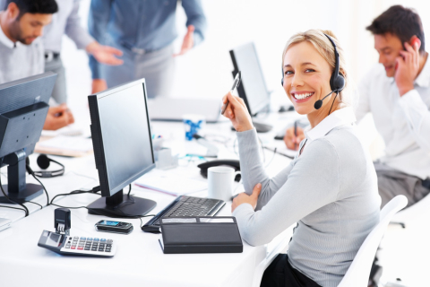 Portrait of happy female customer service executive looking at you and smiling